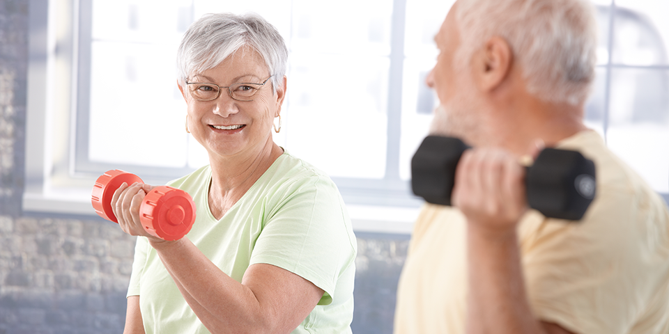 Older couple lifting weights together
